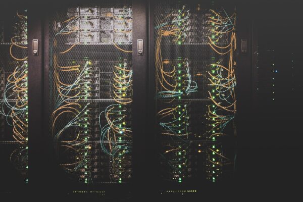 Server racks and network cables in a data center, representing tech's carbon footprint